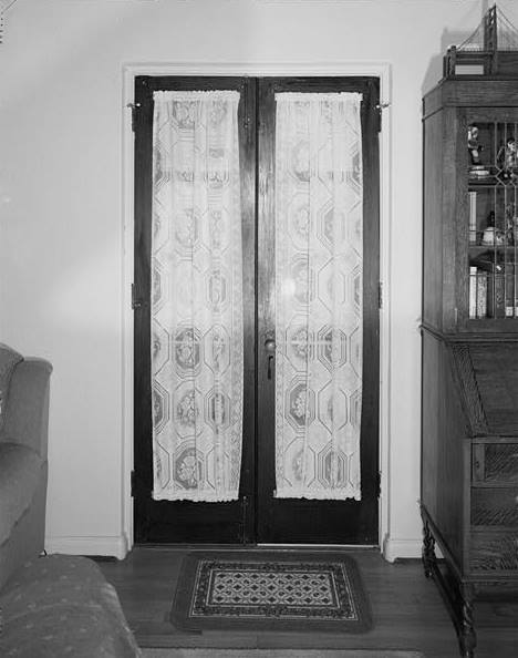  DOUBLE DOORS LEADING FROM LIVING ROOM TO REAR COURTYARD